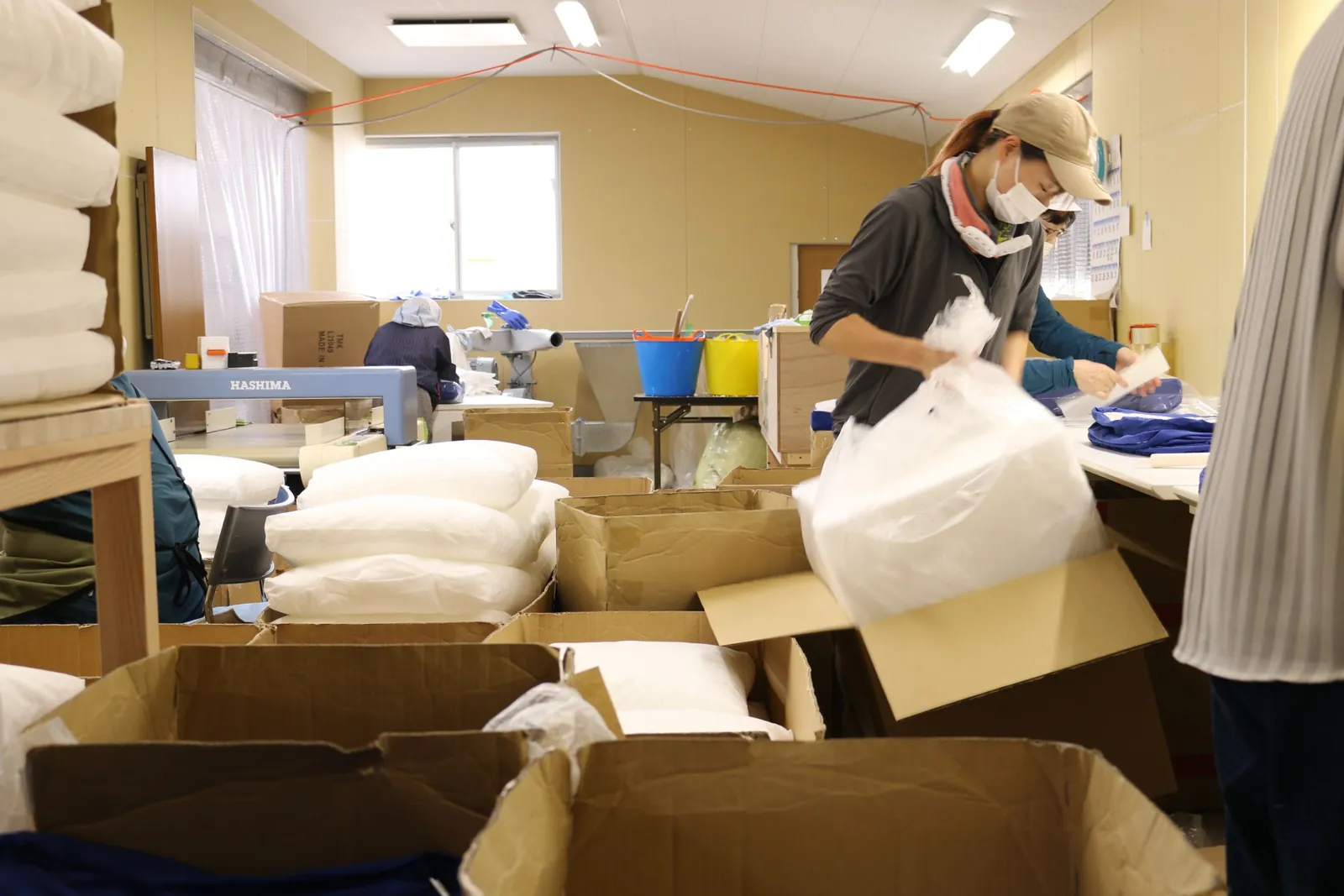 susteb(サステブ)で再生したクッション等の製品を梱包している作業風景
